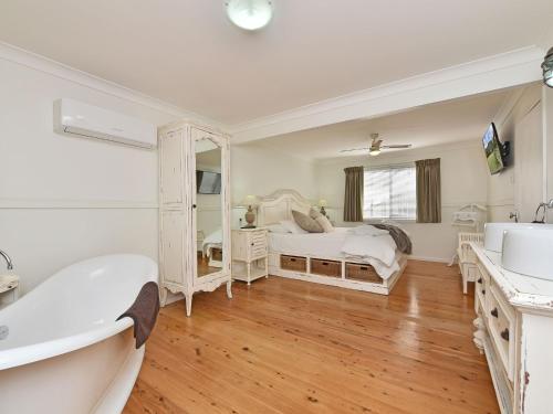 ein Badezimmer mit 2 Betten, einer Badewanne und einem Waschbecken in der Unterkunft Olive Grove 3 1 Bedroom Villa with large Bath in Pokolbin