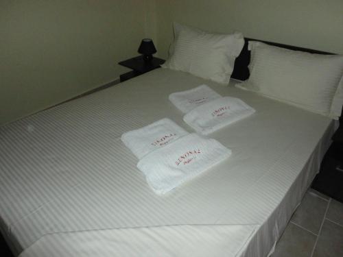 a white bed with two towels on top of it at Luxury House Diakopto in Diakopto