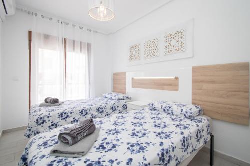 2 Betten in einem blau-weißen Zimmer in der Unterkunft 077 Hidden Paradise - Alicante Holiday in La Mata