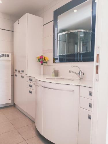 - une cuisine blanche avec un évier et un miroir dans l'établissement Villa Aurelia, à La Turbie