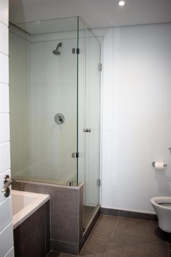 a bathroom with a glass shower and a toilet at Pebble Beach 301 Penthouse, Sibaya in Sibaya