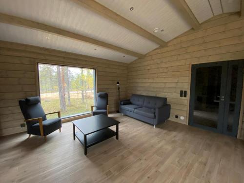 ein Wohnzimmer mit einem Sofa, Stühlen und einem Tisch in der Unterkunft Villas Karhunpesä in Saariselkä