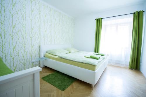 a small bedroom with a bed and a window at Apartments Old Town Square 27 in Prague