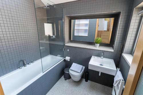 a bathroom with a toilet and a tub and a sink at Stylish Stays by Russel Square in London