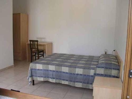 a bedroom with a bed and a table and a chair at Agriturismo Sa Mandria in Castiadas