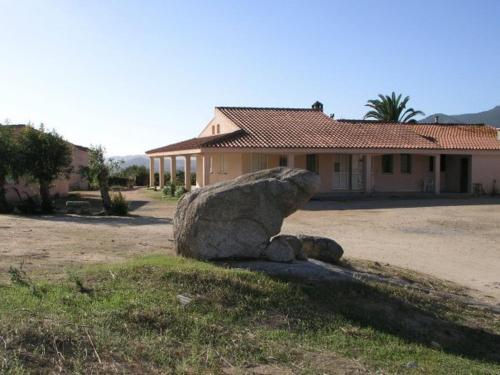a large rock sitting in front of a house at Agriturismo Sa Mandria in Castiadas