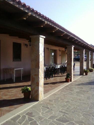a patio with tables and chairs in a building at Agriturismo Sa Mandria in Castiadas