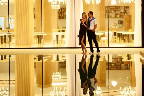 a man and woman standing in front of a building at At Herbal Boutique Hotel & Spa in Protaras