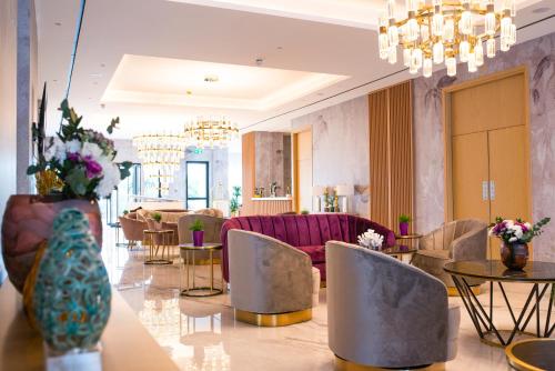 a lobby with a couch and tables and chairs at At Herbal Boutique Hotel & Spa in Protaras