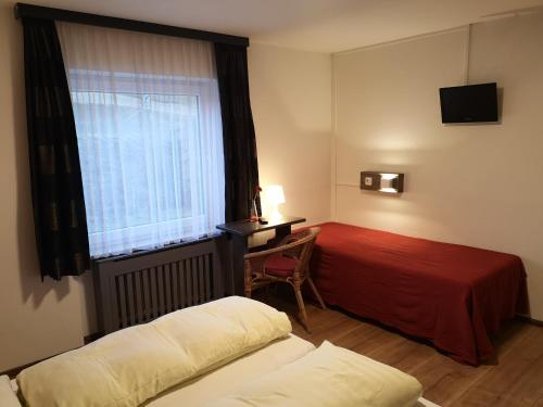 アーヘンキルヒにあるBed & Breakfast Der Tirolerのベッド2台と窓が備わるホテルルームです。