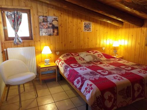 Chalet Plein Sud في مونجينيفر: غرفة نوم بسرير وكرسي ونافذة