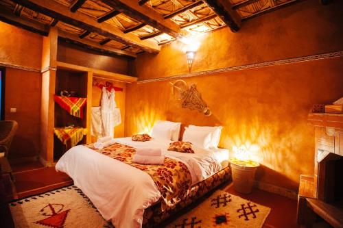 a bedroom with a bed and a fireplace at Kasbah Rayane Ait Ben Haddou in Aït Ben Haddou