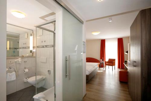 ein Bad mit einer Dusche und einem WC in einem Zimmer in der Unterkunft Landhotel Altes Wasserwerk GbR in Freinsheim