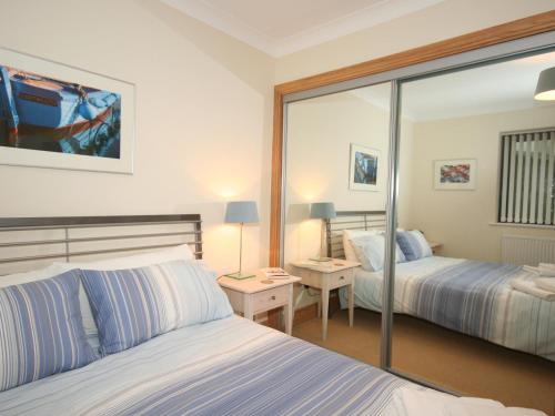 a hotel room with two beds and a mirror at 1 Crabshell Quay in Kingsbridge