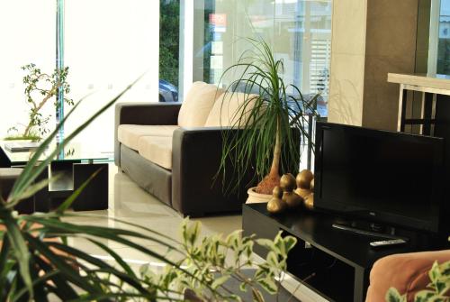 a living room with a couch and a tv at Hotel Castilla in Punta del Este