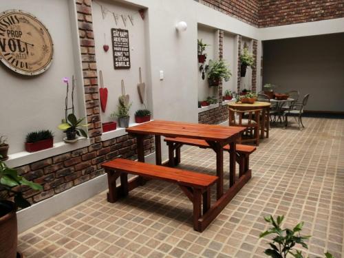 una mesa y bancos en un restaurante con mesas y sillas en Acorn Lodge & SKYDECK, en Potchefstroom