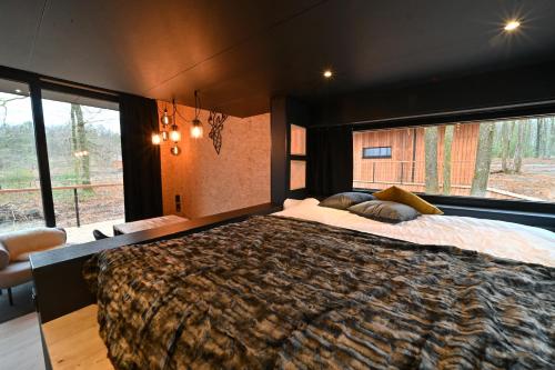 a bedroom with a large bed and a large window at Forest Cube in Oignies-en-Thierache