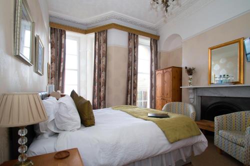 a bedroom with a large bed and a fireplace at The Collingdale Guest House in Ilfracombe
