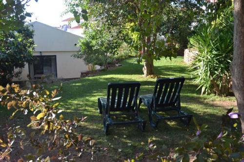 two chairs sitting in the grass in a yard at Garden in the City in Silves