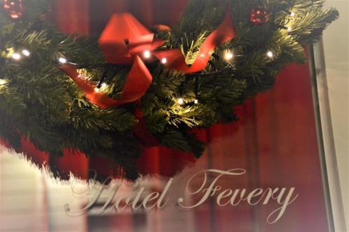 a christmas wreath with a red bow on a door at Hotel Fevery in Bruges