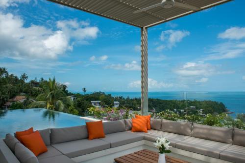 a living room with a couch and a swimming pool at Bay Villas Koh Phangan in Salad Beach
