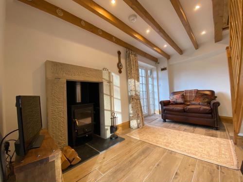 a living room with a couch and a fireplace at Robin Hood Tower in Crich