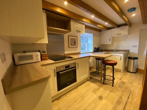 a kitchen with white cabinets and a counter top at Robin Hood Tower in Crich