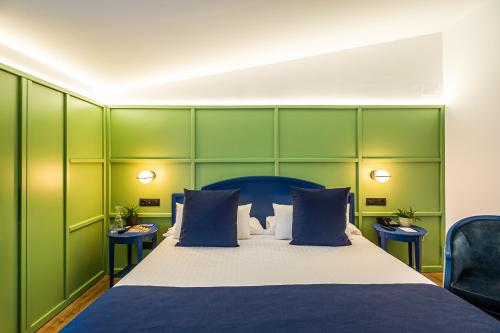 a bedroom with a large bed with green walls at Intelier Rosa in Castellón de la Plana