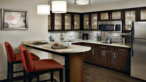 a kitchen with a kitchen island with a refrigerator at Staybridge Suites Irvine - John Wayne Airport by IHG in Irvine