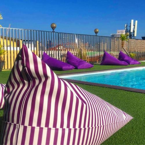 a group of pillows sitting next to a pool at Embryo Hotel  in Pattaya Central