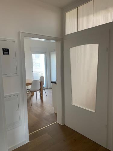 a room with white walls and a dining room with a table at ARGENTA Living 2 in Fulda
