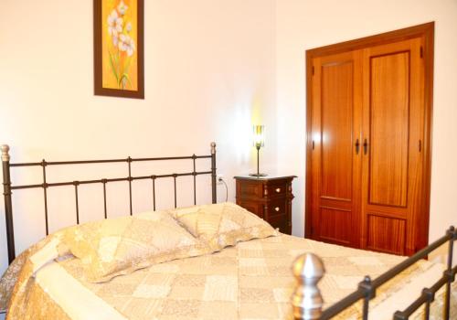 um quarto com uma cama e uma porta de madeira em Casa Rural Aya I em Linares de la Sierra