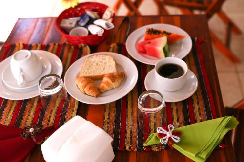 a table with plates of food and a cup of coffee at AYRE GOSTOSO POUSADA in São Miguel do Gostoso