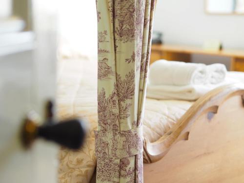 a close up of a bed with a curtain at The Old Manse Pickering in Pickering