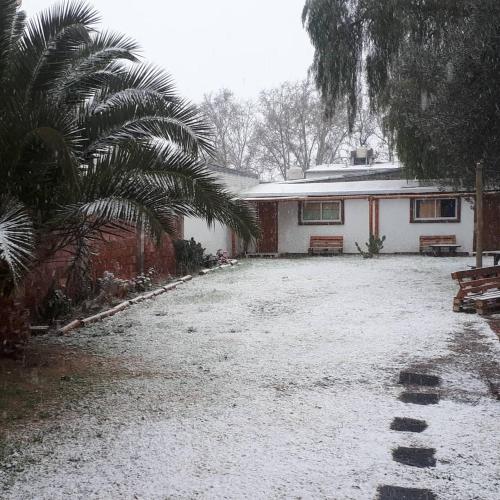 a yard covered in snow next to a house at SIGRUM Hostel in San Rafael
