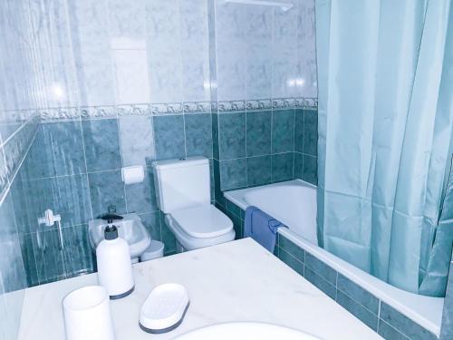 La salle de bains est pourvue de toilettes, d'une baignoire et d'un lavabo. dans l'établissement Apartamento T2 Carvoeiro-Lagoa preços acessíveis, à Lagoa