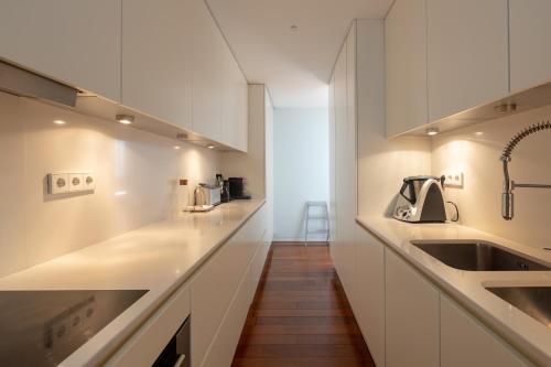 eine Küche mit weißen Schränken und einem Waschbecken in der Unterkunft River house in Porto