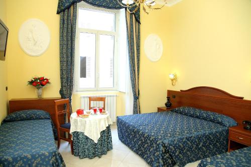 a hotel room with two beds and a window at Caroline Suite in Rome