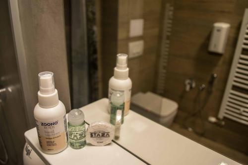 a bathroom with three bottles of soap and a mirror at Staza Resort in Bjelašnica