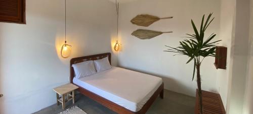 a bedroom with a bed and a potted plant at Bambo Villa in Paracuru