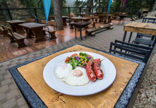 einen Teller Eier Würstchen und Salat auf dem Tisch in der Unterkunft Staza Resort in Bjelašnica