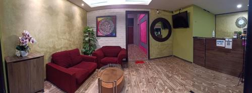 a waiting room with red chairs and a mirror at Tc theme park Guest house in Kuantan