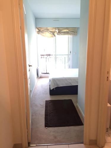 une chambre avec un lit et une grande fenêtre dans l'établissement Appartamento in centro a Mentone vicino alla spiaggia Parcheggio privato INCLUSO!, à Menton