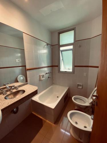 a bathroom with a tub and a toilet and a sink at Hotel Riviera in Córdoba