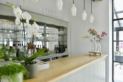 a bar with vases of flowers on a counter at B&B O Chocolat Cho in Sint-Pieters-Leeuw