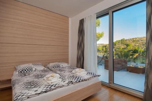 Tempat tidur dalam kamar di Luxury Beachfront Villa Blue Star of Brac with private pool at the beach on Brac island - Bobovisca