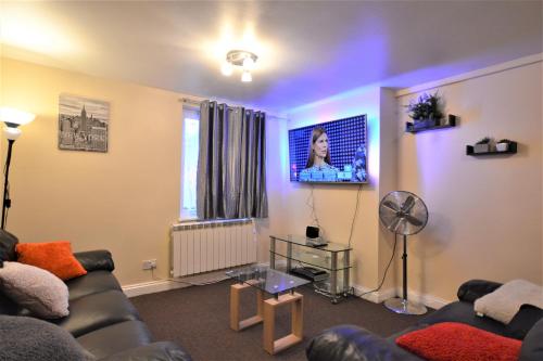 a living room with a couch and a tv at London Zone 2 Lovely 4 bedroom Apartment - 3 Trowbridge Road in London