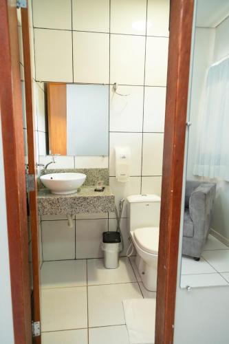 a small bathroom with a toilet and a sink at Hotel BR 364 in Cacoal