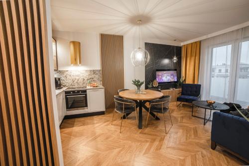 cocina y sala de estar con mesa y sillas en Apartament Warmiński by RENT4YOU, en Olsztyn