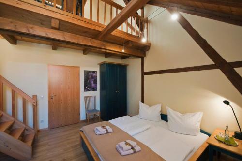 a bedroom with a large bed in a room with wooden ceilings at Zur Goldenen Kartoffel in Prötzel